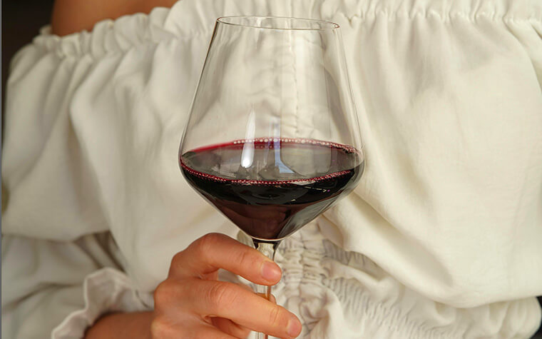 Frau haelt ein glas Cantele Primitivo in der Hand