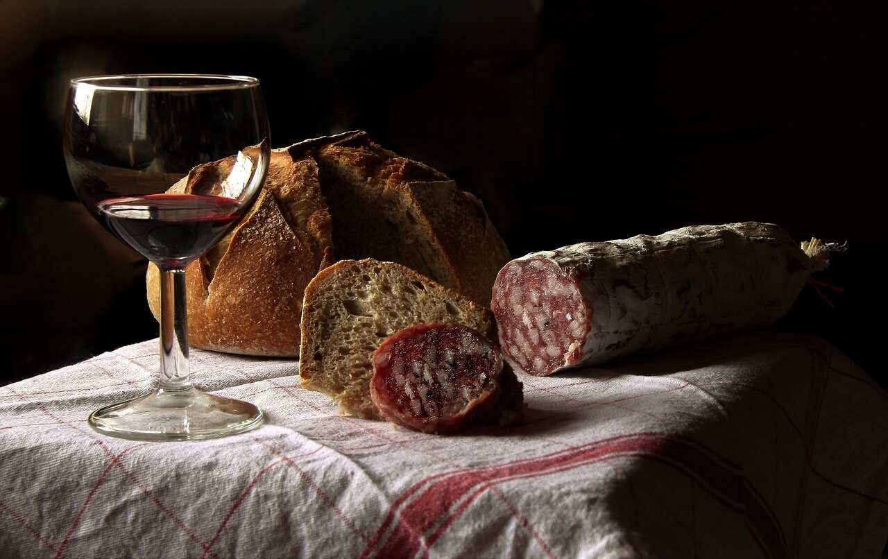 Ein Glas cantele primitivo vor frischem Brot und Salami