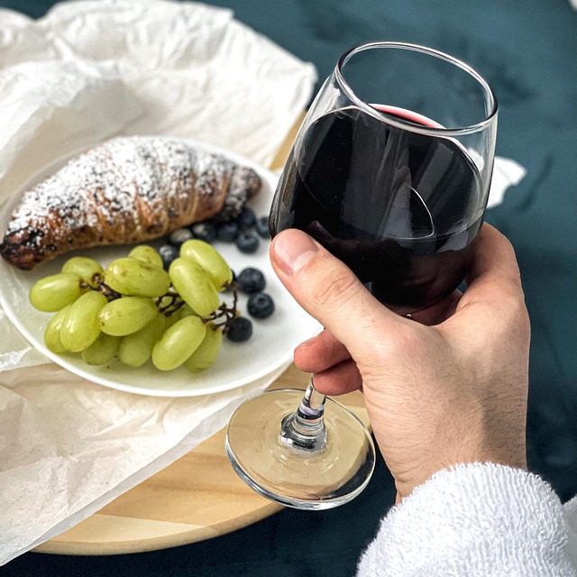 Ein Glas e mezzo Primitivo mit einem Croissant und Weintrauben