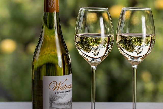 Eine Flasche guter Weiwein mit zwei gefllten Glsern auf einem Tisch