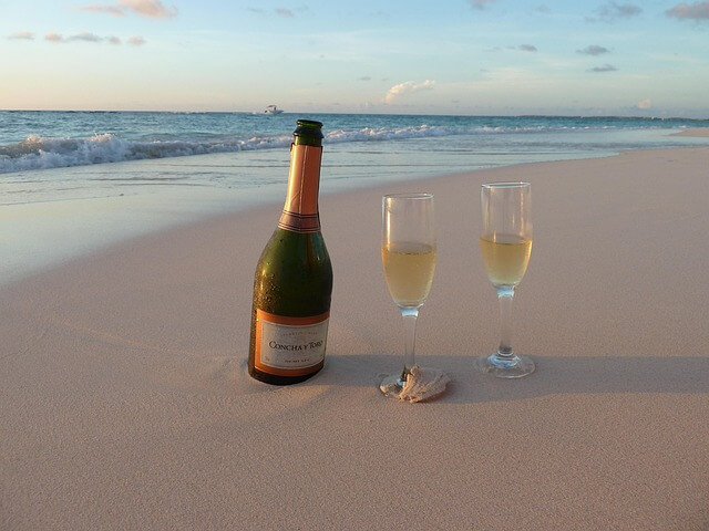 Eine Flasche bouvet cremant de loire am Strand mit zwei Glsern im Sand